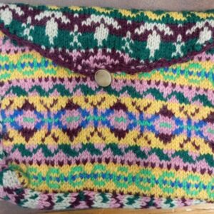 Colorful hand-knitted clutch bag with geometric patterns and button closure.